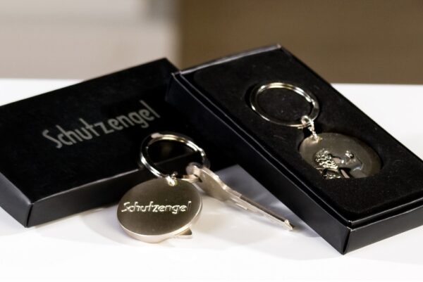 Schlüsselanhänger Schutzengel rund Form - Edelmetall – silber – Gravurfähig Trendiger Schlüsselanhänger Schutzengel rund in Geschenkebox auf der Rückseite mit Text ” Schutzengel” und Möglichkeit zur persönlichen Gravur. Vorderseite mit Schutzengel Abbildung in Hochglanz aus mattem und glänzendem silberfarbenem Edelmetall aus Edelmetall · runde Form Rückseite: "Schutzengel" und Möglichkeit zur persönlichen Gravur Vorderseite: mit Schutzengel-Abbildung in Hochglanz in schwarzer Geschenkbox Breite: 7,50 cm Lieferumfang : 1 Schlüsselanhänger im Casablanca Geschenkkarton Schutzengel Schlüsselanhänger 40780